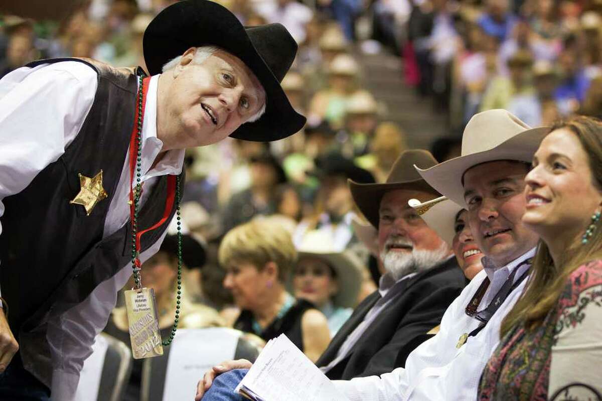 Rodeo vice president Jerry Hickman looks back toward the competing bidders after the team of Dick Scott, Dodie Juarez and Parker and Victoria Johnson raised their bid for the Reserve Grand Champion during the Junior Market Steer Auction at the Houston Livestock Show and Rodeo.