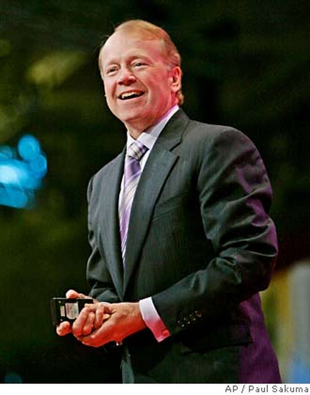 ** FILE ** Cisco Systems CEO John Chambers smiles during a keynote address at the Oracle Open World conference in San Francisco, in this Oct. 24, 2006, file photo. Chambers received compensation the company valued at $12.8 million in fiscal 2007, though his total pay package was actually much higher as he cashed out $50.9 million in stock options while the networking gear maker continues to profit mightily from a boom in demand for Internet bandwidth. (AP Photo/Paul Sakuma, file) OCT. 24, 2006 FILE PHOTO
