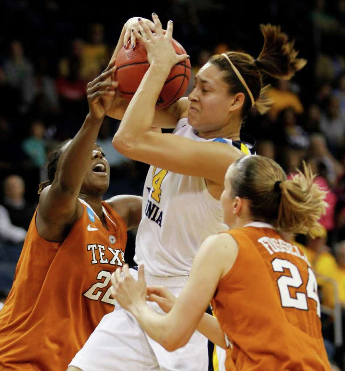 West Virginia forward Jess Harlee (14) goes up strong between Texas' Ashley Gayle (22) and Chassidy Fussell in the first half Saturday.
