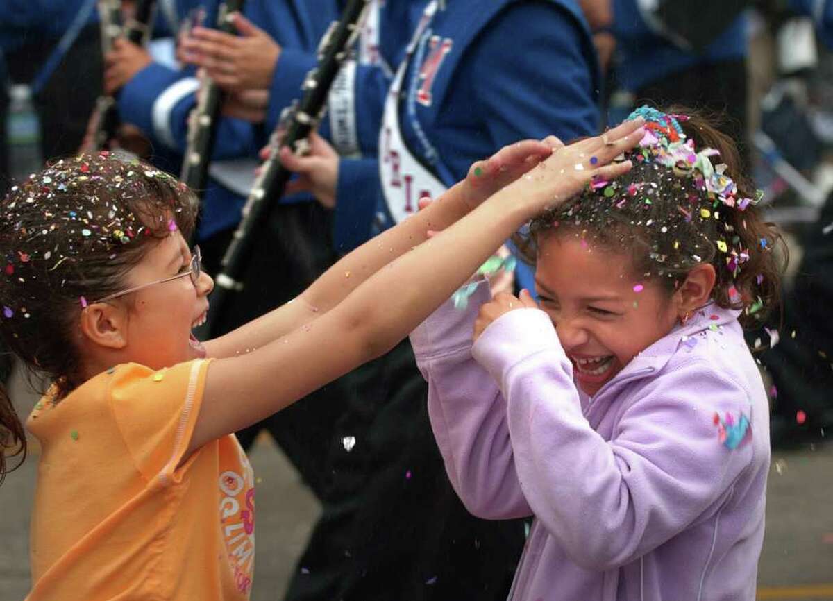 Metro daily - Ember Ayala, left, hits Arianh Campos with Fiesta cascarones during The Battle of Flowers Parade along Broadway, Friday, April 23, 2004. photo Bob Owen