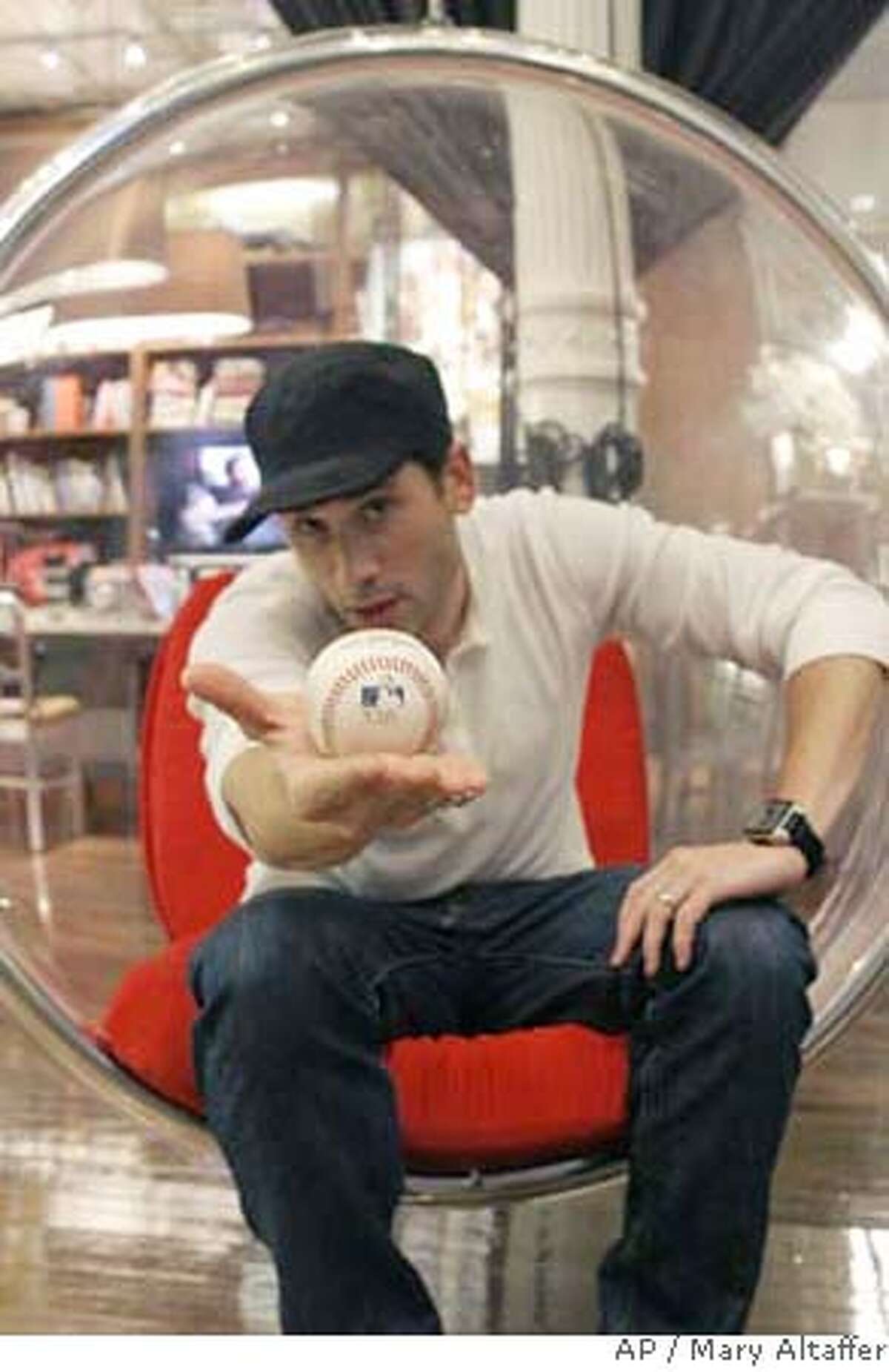 Fashion designer Marc Ecko poses with Barry Bonds' record-breaking home run ball Monday, Sept. 17, 2007, in New York. Ecko was the winning bidder in the online auction for the ball from Bonds' 756th career home run, and has announced that it is now in the public's hands. Ecko announced Monday he was taking votes on whether to give the ball to the Hall of Fame, brand it with an asterisk or blast it into space. (AP Photo/Mary Altaffer)