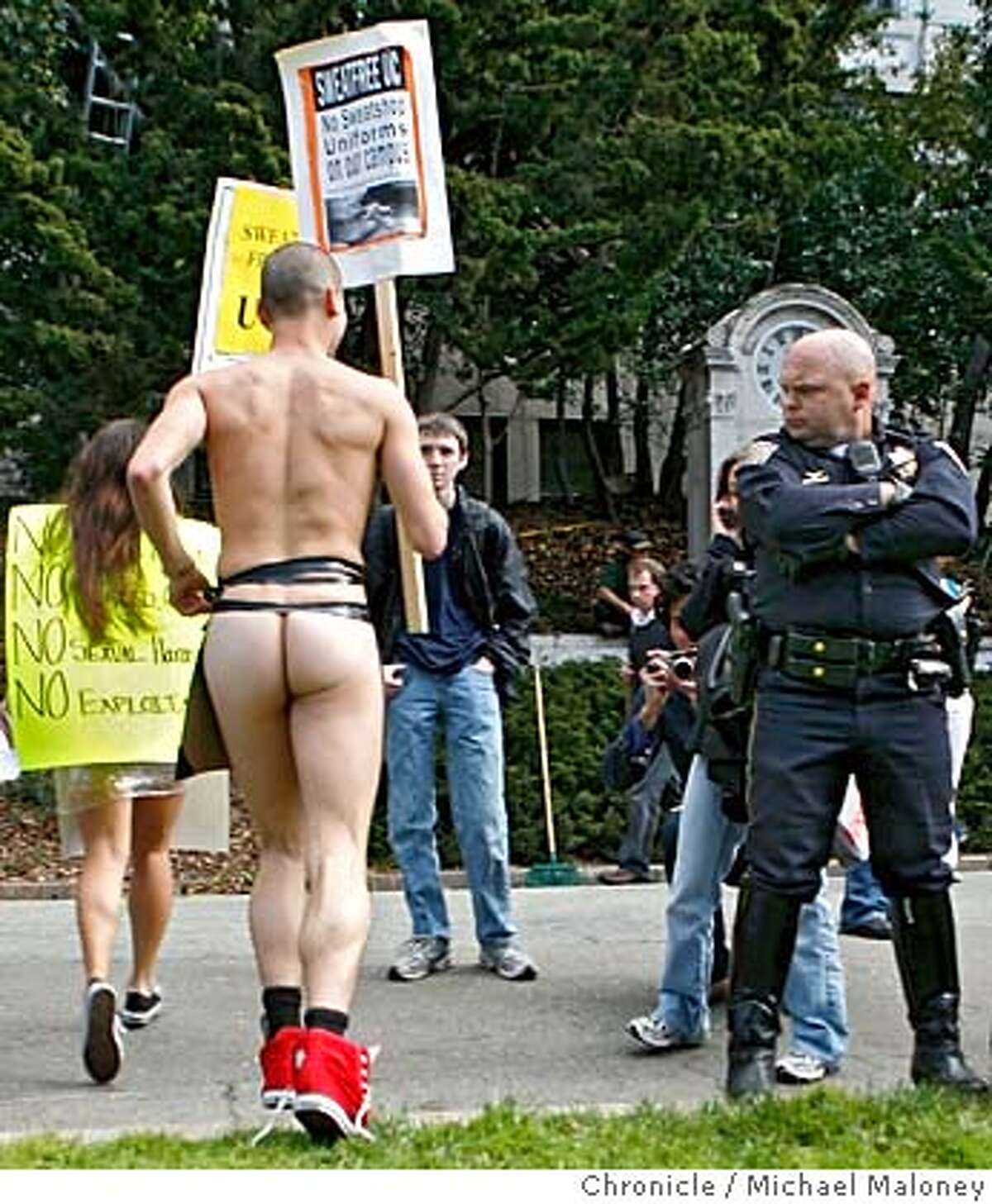 A University of California Police Department Officer, J. Sprecher, watches as some of the protesters circulated among the gawkers. UC Berkeley students in various forms of dress and undress demonstrated outside UCB Chancellor Robert Birgeneau's office at noon today. About 50 students protested UCBerkeley earning royalties from collegiate apparel companies without guaranteeing these companies' fair labor practices. Photo by Michael Maloney / San Francisco Chronicle on 3/1/06 in Berkeley,CA