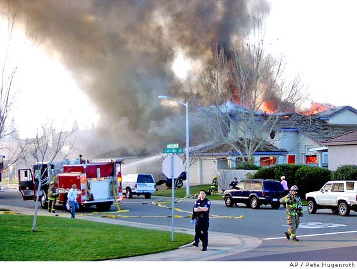 Smoke and flames rise from a home struck by a single engine plane in Roseville, Calif., Sunday, Feb. 12, 2006. The pilot of the plane was killed in the crash. (AP Photo/Pete Hugenroth)