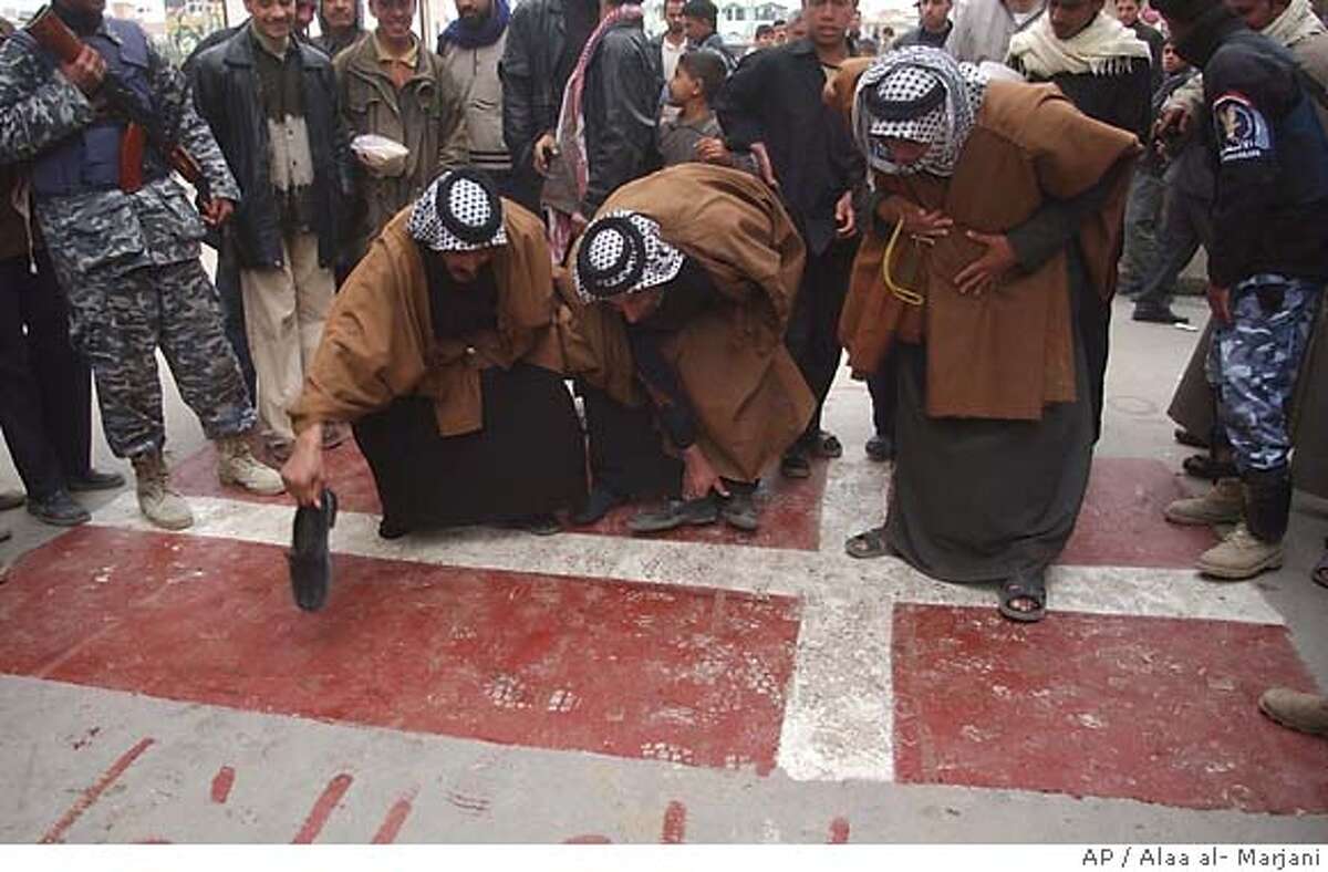Iraqi Shiite Muslims stomp on a painting of the Danish flag denouncing the country's publication of a cartoon of the Muslim prophet Muhammad, Thursday, Feb. 2, 2006, in the holy city of Najaf, 160 kilometers (100 miles) south of Baghdad, Iraq. Denmark is receiving Muslim protests over the newspaper cartoons of the Prophet Muhammad published in one of their major news publications. A series of caricatures, published Sept. 30 in the Danish Jyllands-Posten daily, angered Muslims that show the prophet Muhammad wearing a turban shaped as a bomb with a burning fuse. (AP Photo/Alaa al- Marjani)
