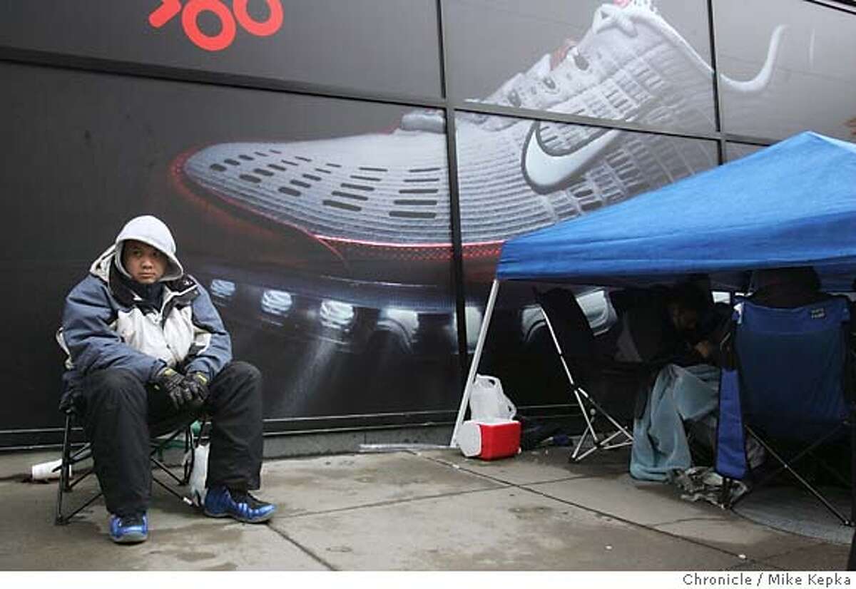 Wilson Woo, 29, of San Francisco has been waiting since Wednesday for his new set of Jordans to add to his collection of 200 plus pairs of collectors shoes he already has at home. Woo said he took a week off from the shoe store he works at to wait in front of the Union Square store. Nike shoe collectors wait outside San Francisco's Nike Town store, some as long as a week, for a the chance to spend $300 for a set of limited edition Air Jordans released under the name "Defining Moments." san francisco on 1/27/06. Mike Kepka / The Chronicle