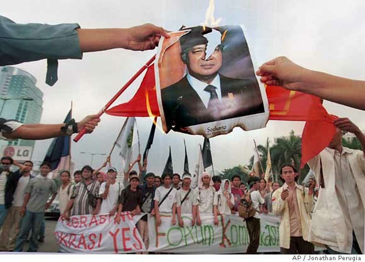 Members of Indonesia's Student Forum for Reform and Democracy burn a portrait of former President Suharto during their protest against the former president and the ruling Golkar Party in downtown Jakarta Friday, May 21, 1999. Suharto stepped down after a nationwide protest and riot against his 32-year rule last year. (AP Photo/Jonathan Perugia) Ran on: 01-15-2006 Indonesian Student Forum for Reform and Democracy members burn a portrait of President Suharto a year after he resigned.