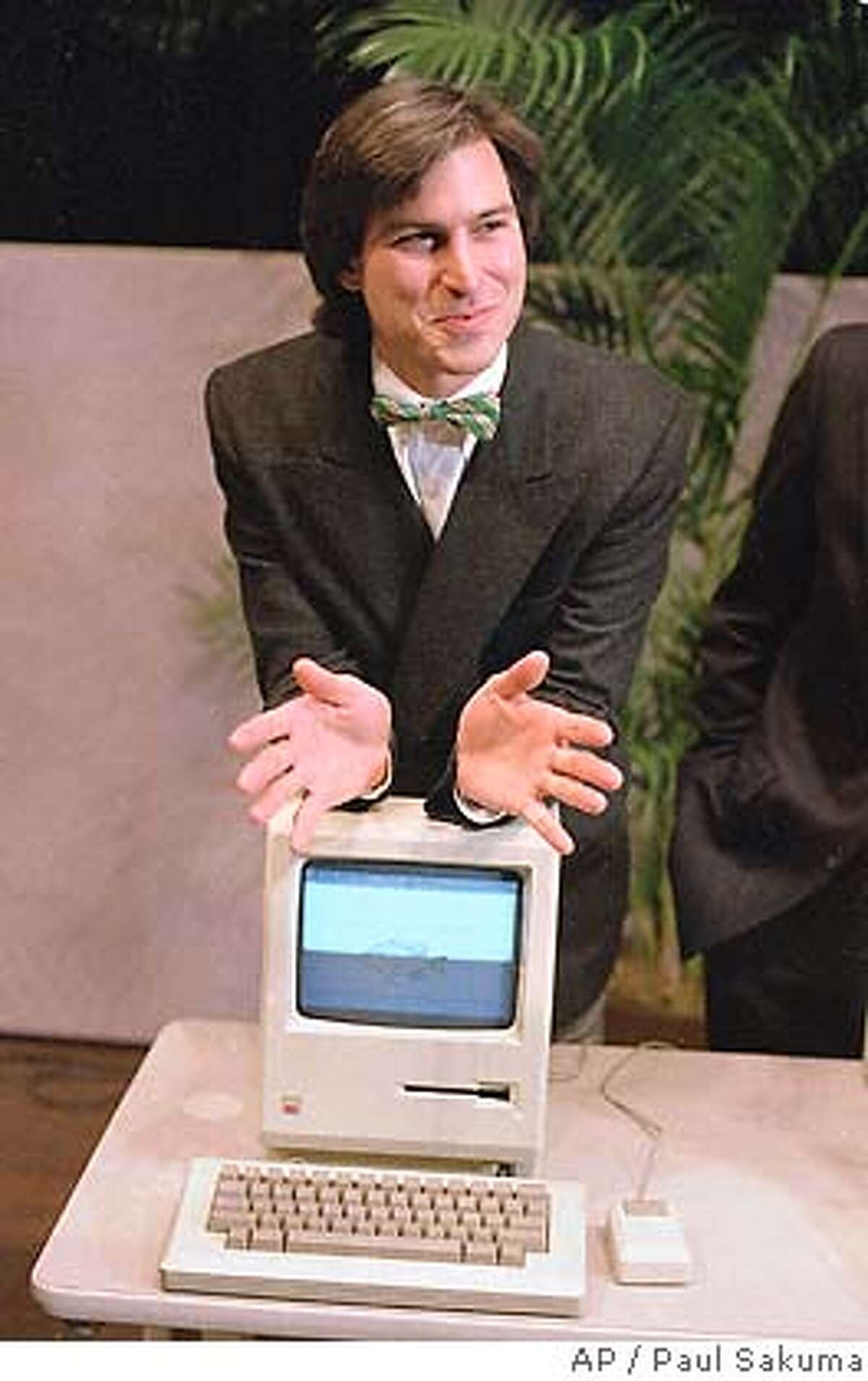 Steven Jobs, chairman of the board of Apple Computer, leans on the new "Macintosh" personal comptuer following a shareholder's meeting Jan. 24, 1984 in Cupertino, Ca. The Macintosh, priced at $2,495, is challenfing IBM in the personal computer market. (AP Photo/Paul Sakuma)