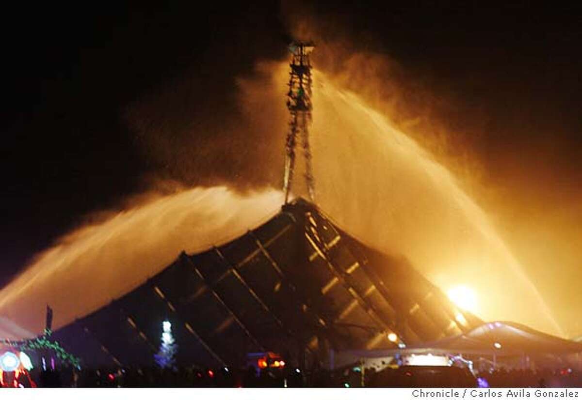 Burning_Man_0002_CAG.JPG Firefighters blast water at the man to extinguish an attempted arson on the fire festival icon. The art structure known as The Man, the center of the Burning Man Festival in the Nevada desert, was set afire on Tuesday morning, August 28, 2007. An unknown man allegedly climbed the structure from within, and was reported to have placed an object in the leg of The Man which then ignited and set the wooden structure burning five days before it was officially supposed to be burned. The suspect was taken into custody by Bureau of Land Management rangers patrolling the festival. Photo by Carlos Avila Gonzalez/The Chronicle Photo taken on 8/28/07, in Black Rock City, Nv, USA. **All names cq (source)