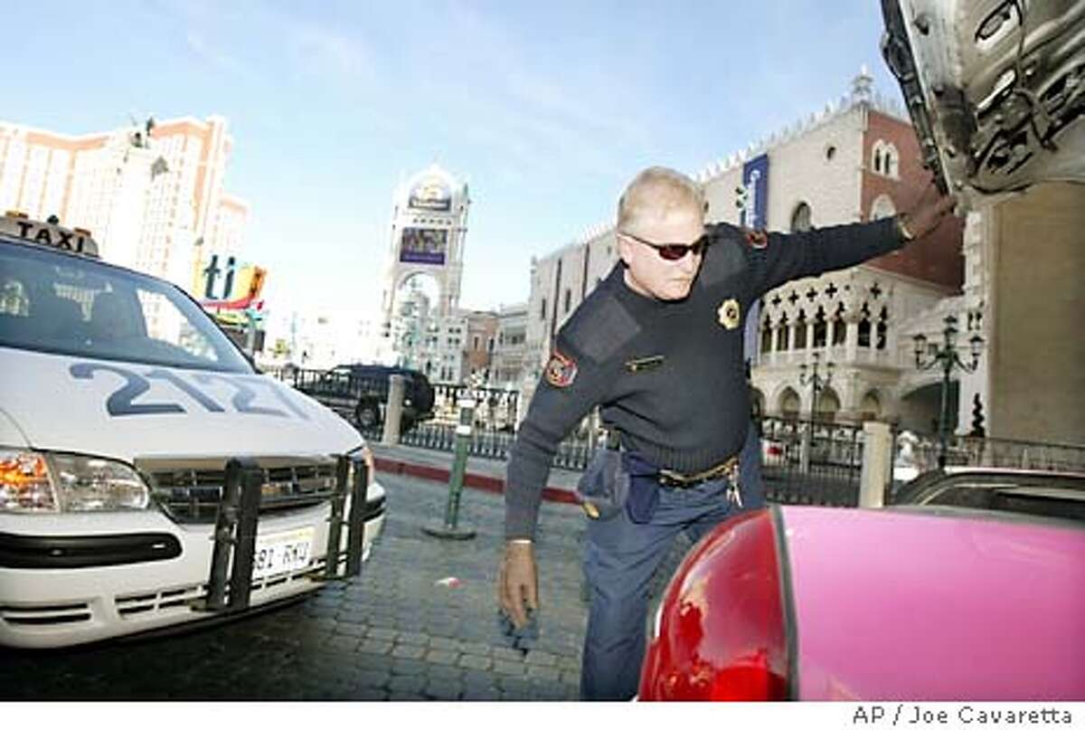 William Silvey, security officer for the Venetian Hotel and Casino checks the trunk of a car entering the parking garage Monday, Dec. 22, 2003 on the Las Vegas Blvd. "strip." As the terror threat level is raised, most Las Vegas resorts are taking precautions such as searching cars entering the properties.(AP Photo/Joe Cavaretta) Security guard William Silvey checks the trunk of a car entering a casino parking garage in Las Vegas.