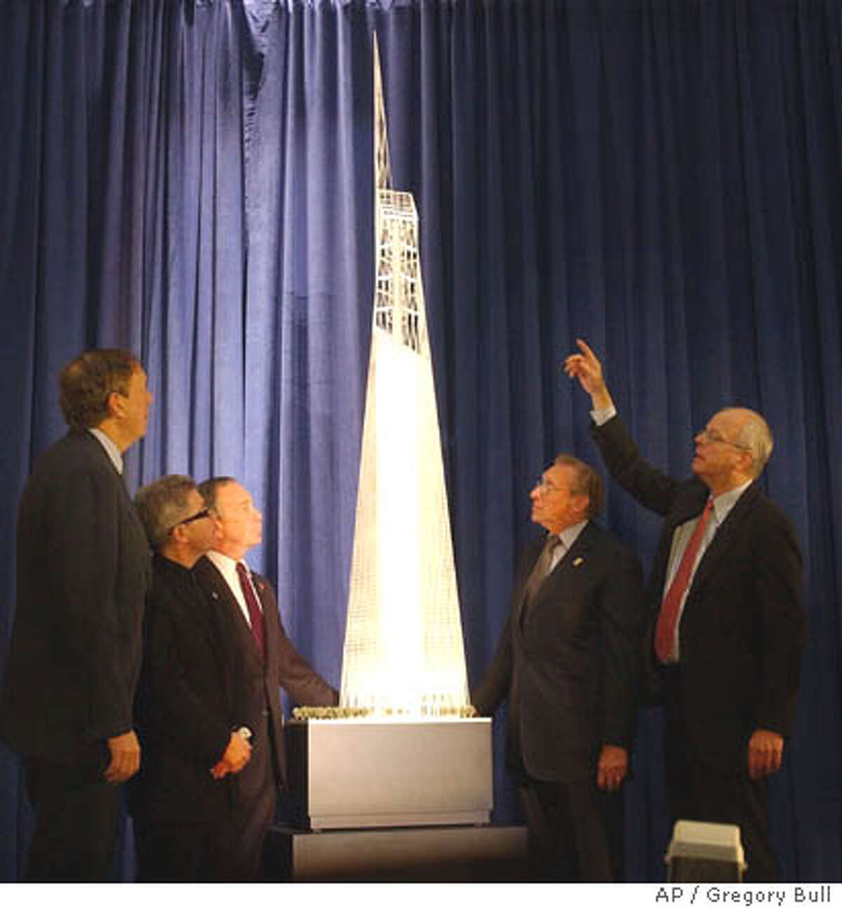 Architect David Childs, right, gestures while looking at a model of the design for the Freedom Tower to be built on the World Trade Center site during an unveiling ceremony in Federal Hall, New York, Friday, Dec. 19, 2003. Looking on, from left, are New York Gov. George Pataki, architect Daniel Libeskind, New York City Mayor Michael Bloomberg, and Larry Silverstein. (AP Photo/Gregory Bull)