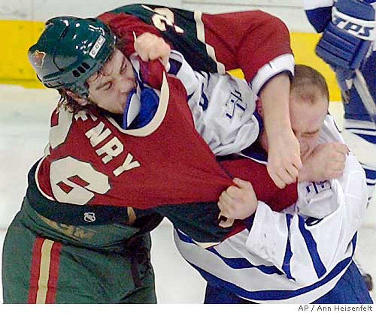 Minnesota Wild defenseman Alex Henry, left, takes a swing at Toronto Maple Leafs right wing Tie Domi, right, as Domi tries to pull Henry's jersey over his head during a second-period fight in St. Paul, Minn., Thursday, Dec. 11, 2003. Both players received major penalties for fighting. The Maple Leafs won 1-0. (AP Photo/Ann Heisenfelt)