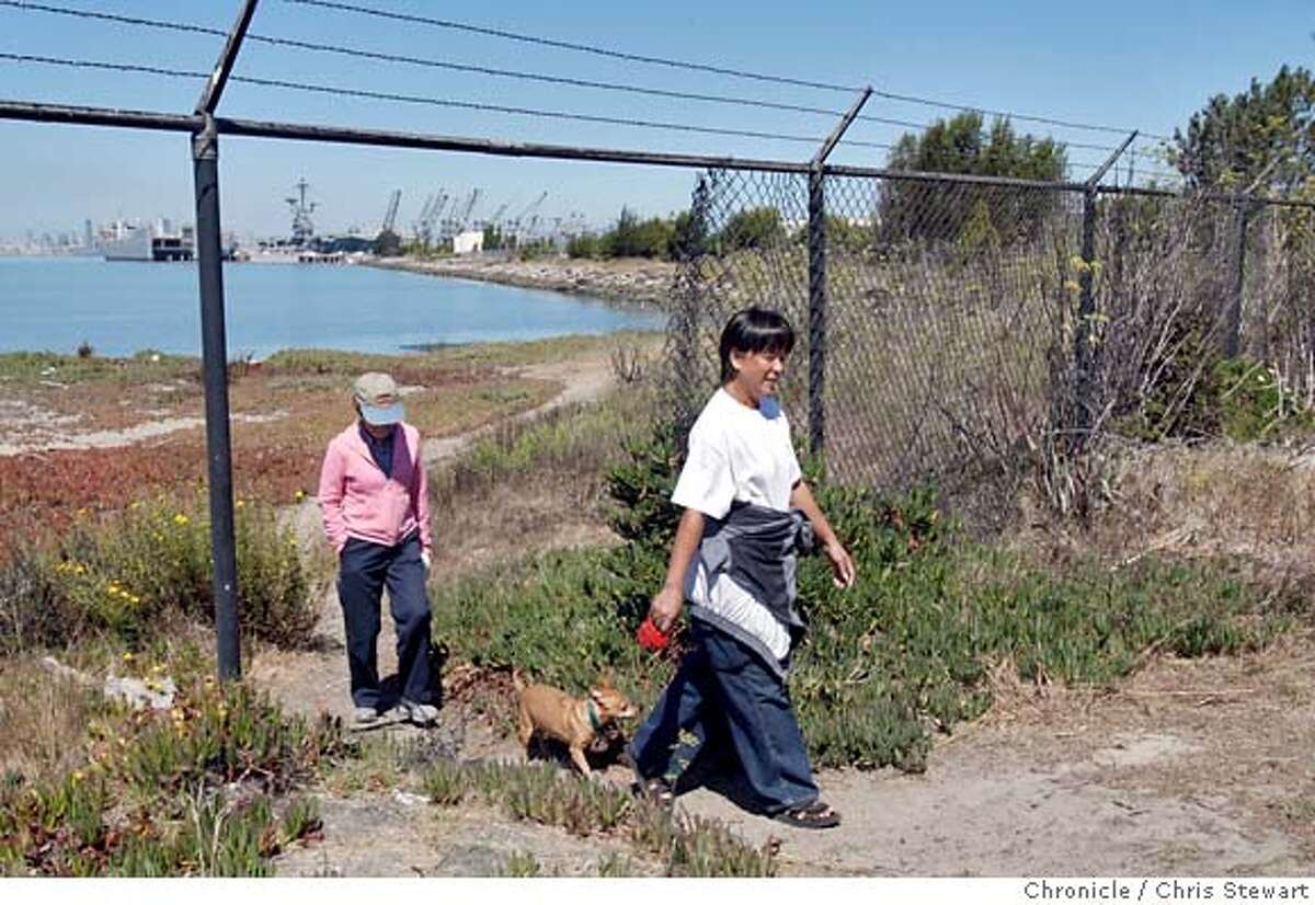 TRAIL20_0005_cs.jpg Event on 8/17/07 in Alameda Ella Pennington (cq - right), of San Leandro, leads her dog Cuervo and Linda Berggren (cq), of Alameda, following a hike along what will be a new trail opening to the public at Alameda Point, site of the former Alameda Naval Air Station. It will open up the formerly off-limits shoreline to the public between the Encinal Boat Ramp and the aircraft carrier USS Hornet. The 2600 foot shoreline will feature a new paved trail, benches and the removal of a 635-foot-long chain link fence that blocked access to the shore. Photographed August 17, 2007. Chris Stewart / The Chronicle Trail20, Ella Pennington, Linda Berggren MANDATORY CREDIT FOR PHOTOG AND SF CHRONICLE/NO SALES-MAGS OUT
