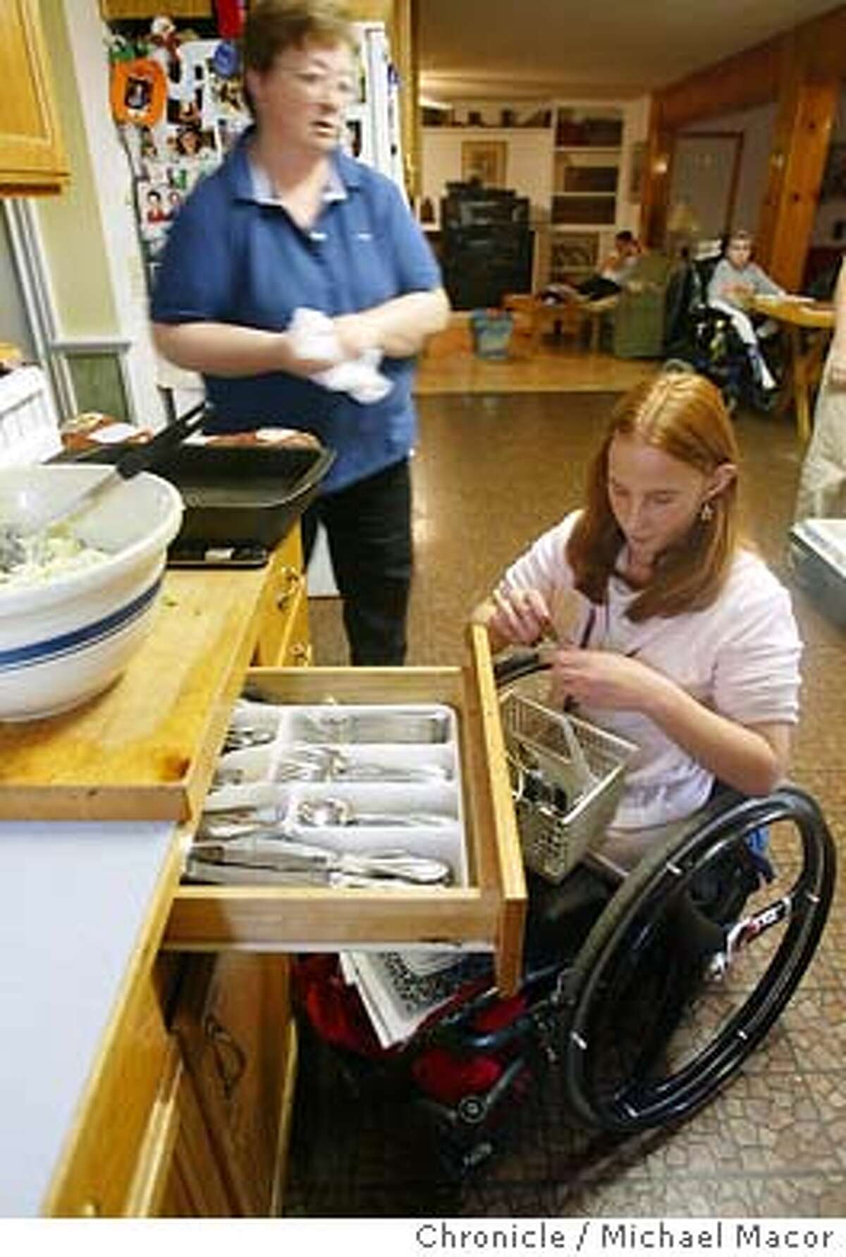 Most everyone helps out around the house and dinner time. Xenia,16 empties the dishwasher, putting away silverware. Susan Tom of Fairfield, has taken 9 disabled children into her home. Jonathan Karsh the former host of Evening Magazine, completed a documentary film on their lives . The film has received awards at the Sundance Film Festival as well as being included in the short list, (top 12 films) being considered as oscar contenders. 11/18/03 in Fairfield. MICHAEL MACOR/ The Chronicle Susan Tom puts her arm around 8-year-old Faith, who suffered severe burns when she was a baby.
