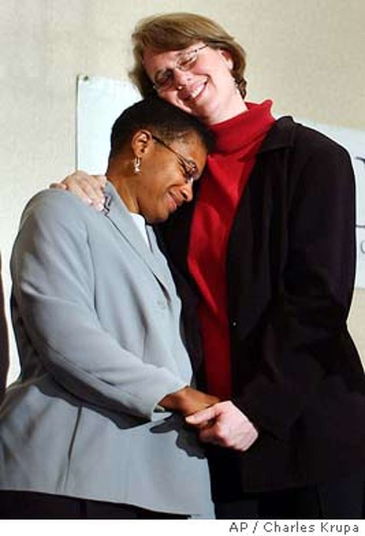 Heidi Norton, right, rests her head on her partner Gina Smith, both of Northampton, Mass., during a news conference regarding the Massachusetts Supreme Judicial Court's ruling that same-sex couples are legally entitled to wed under the state constitution in Boston, Tuesday Nov. 18, 2003. (AP Photo/Charles Krupa)