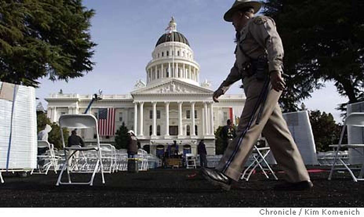 Preparations continue Saturday at the state capitol for the Monday inauguration of Arnold Schwarzenegger. CHP Officer Richard Moss patrols the stands . KIM KOMENICH/The Chronicle