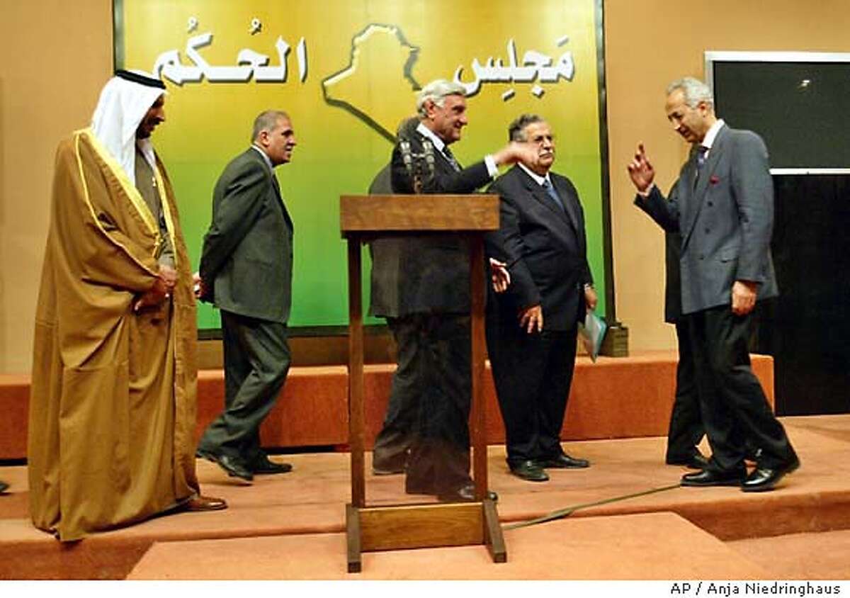 Members of the Iraqi Governing Council with Iraqi Council President Jalal Talabani, center right, arrive for a press conference in Baghdad, Saturday, Nov 15, 2003. The U.S.-led occupation will end by June after selection of transitional government, the Iraqi Governing Council said Saturday. After that, the U.S. military status would change from an occupation force to a "military presence," the council president said. (AP Photo/Anja Niedringhaus)