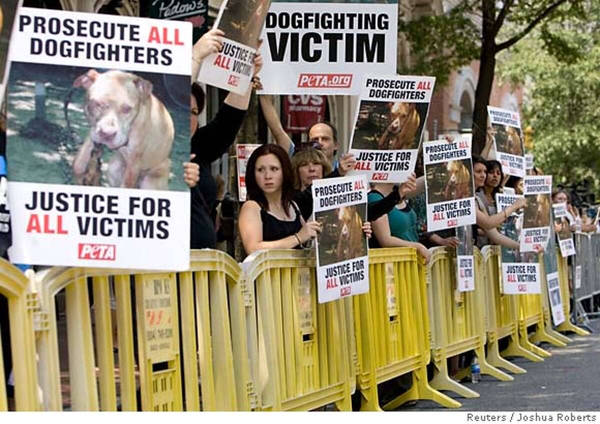 Animal rights protesters hold up placards denouncing cruelty to animals before Atlanta Falcon's quarterback Michael Vick's arrival in federal court to face federal dog fighting charges in Richmond, Virginia July 26, 2007. REUTERS/Joshua Roberts (UNITED STATES) 0