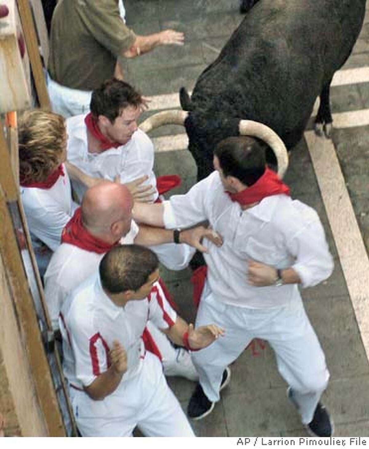 ** CORRECTS SPELLING TO LAWRENCE ** U.S. brothers Lawrence, left, and Michael Lenahan are seen an instant before being gored at the same time by a fighting bull during a traditional bull run in Pamplona, Spain, Thursday July 12, 2007. The two brothers were gored Thursday during the longest and bloodiest morning bull run at the San Fermin festival in the northeastern city of Pamplona. Lawrence Lenahan, 26, of Hermosa Beach, Calif. and Michael Lenahan, 23, of Philadelphia, Pa. were gored by a bull who strayed from the pack, turned around and ran the wrong way. (AP Photo/ Larrion Pimoulier) EFE OUT, PHOTO MADE AVAILABLE FRIDAY JULY 13, 2007 CORRECTS SPELLING TO LAWRENCE