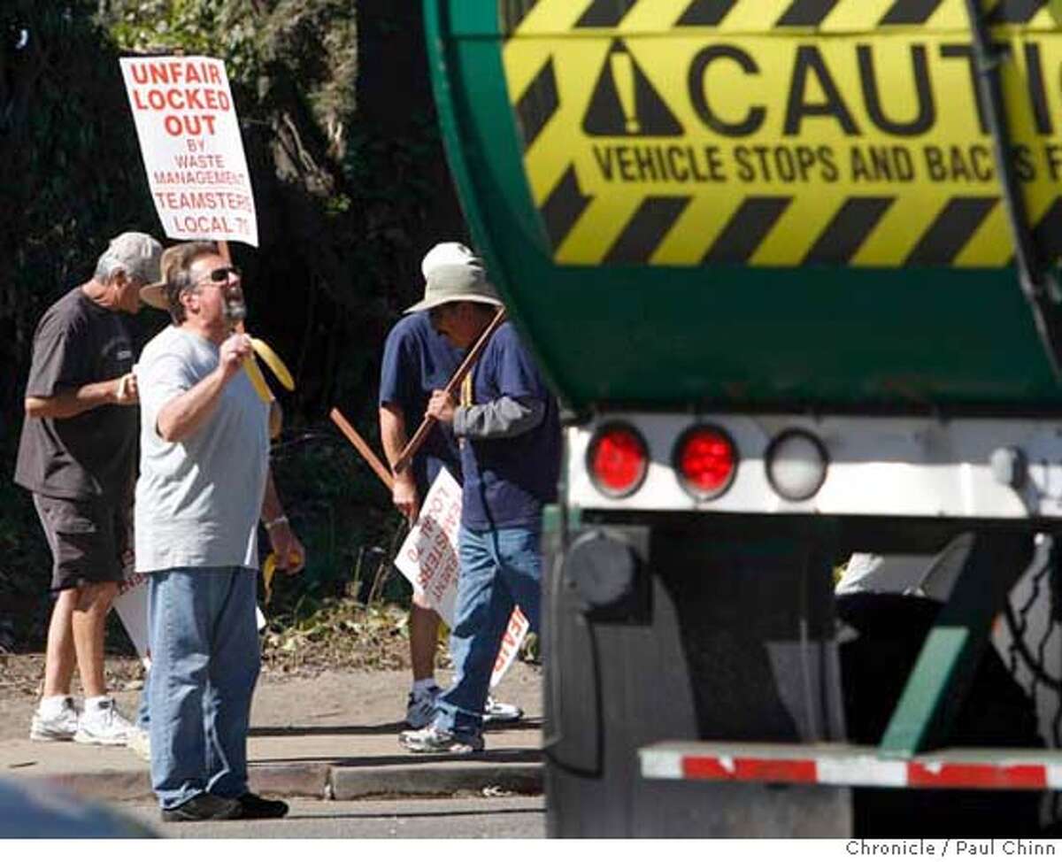 An unidentified locked-out employee walking the picket line taunts a replacement worker with a banana peel at the Waste Management transfer station in San Leandro, Calif. on Thursday, July 19, 2007 as the labor dispute between Waste Management and union workers continues. PAUL CHINN/The Chronicle Ran on: 07-20-2007 Locked out Waste Management employees picket at a San Leandro transfer station. Ran on: 07-20-2007
