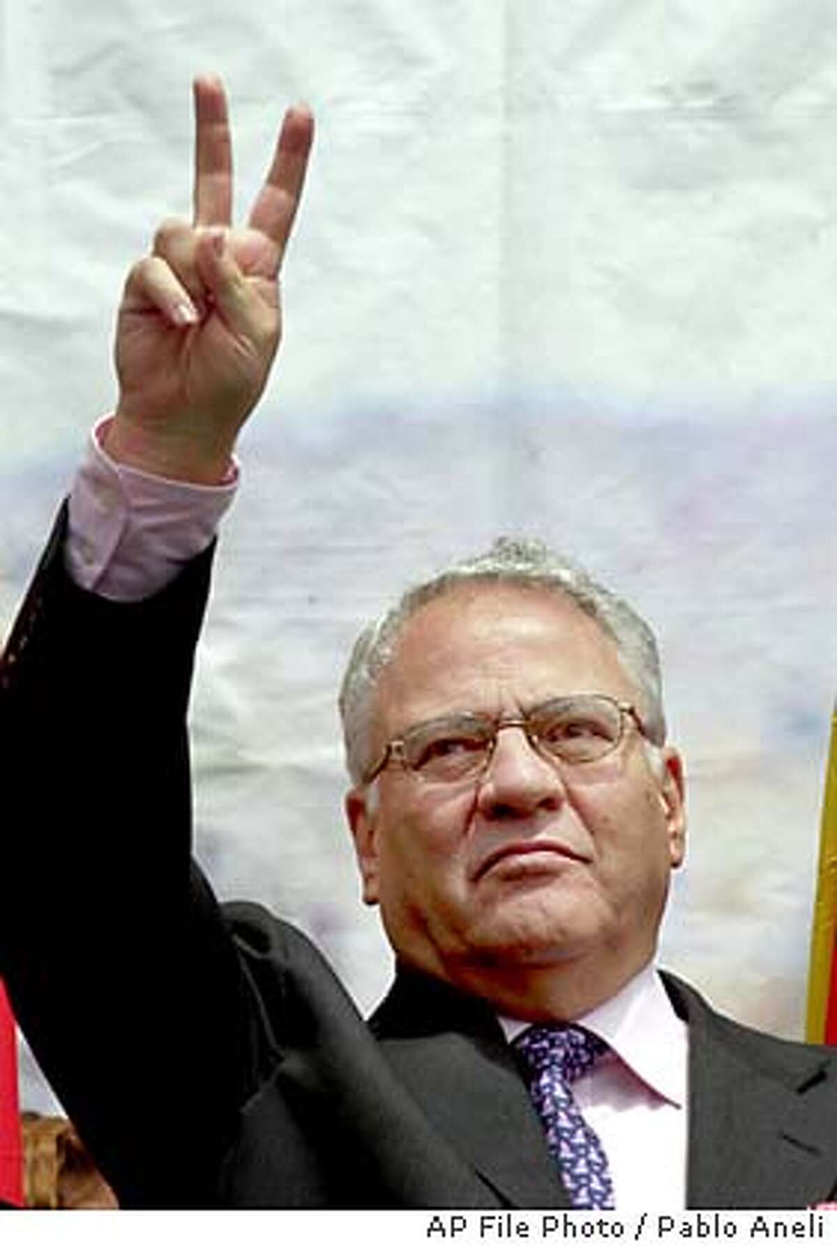 ** FILE ** Bolivian President Gonzalo Sanchez de Lozada, a businessman nicknamed ``Goni'', greets supporters in this April 9, 2002 file photo. The U.S.-educated millionaire who took office for a second term in August 2002 will resign Friday Oct. 17, 2003 after weeks of deadly street riots triggered by a goverment plan to export natural gas, a presidential aide said Friday. (AP Photo/Pablo Aneli, File)