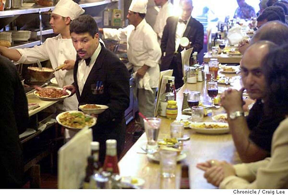 Original Joe's restaurant in the Tenderloin district of San Francisco. Photo of waiter, Sergio Morales (left), hustling out a dinner order from behind the counter. He was on his way out to the main dining room. CRAIG LEE / The Chronicle