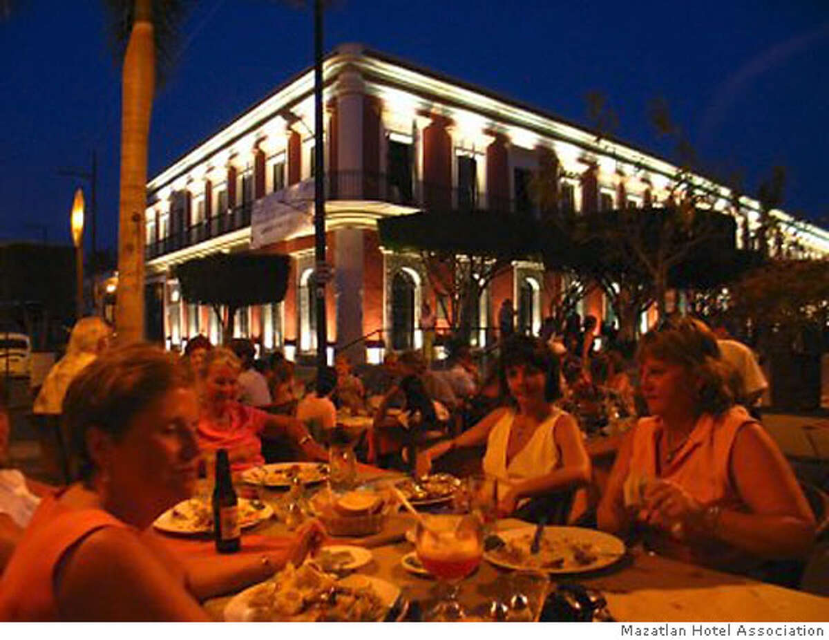 TRAVEL MAZATLAN -- Plazuela Machado is ringed by outdoor cafes; the restored Angela Peralta Theater building rises in the background. with outdoor diners in the evening tables Credit: Mazatlan Hotel Association