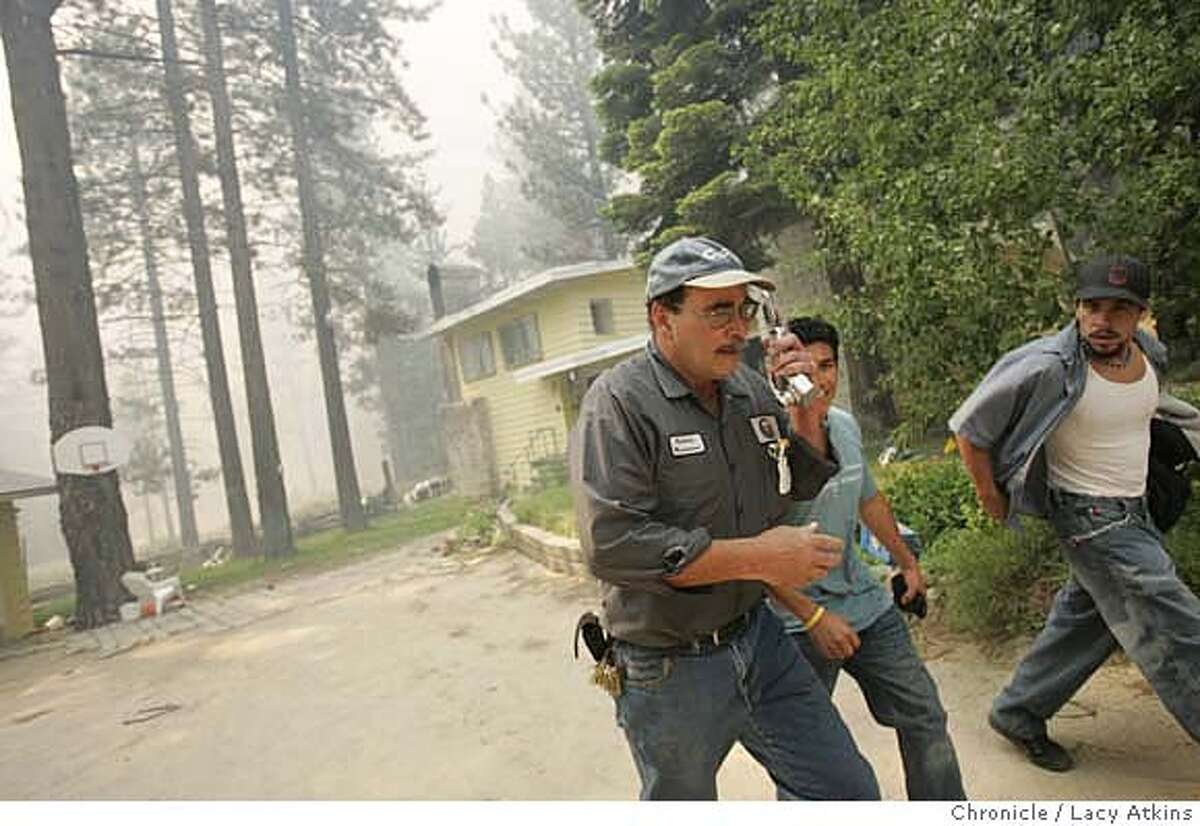 Mark Anthenien tries to make a call as he and his sons Jason and Greg evacuate their home as the flame get closer,Tuesday June 26, 2007, in South Lake Tahoe, Ca. (Lacy Atkins /San Francisco Chronicle)