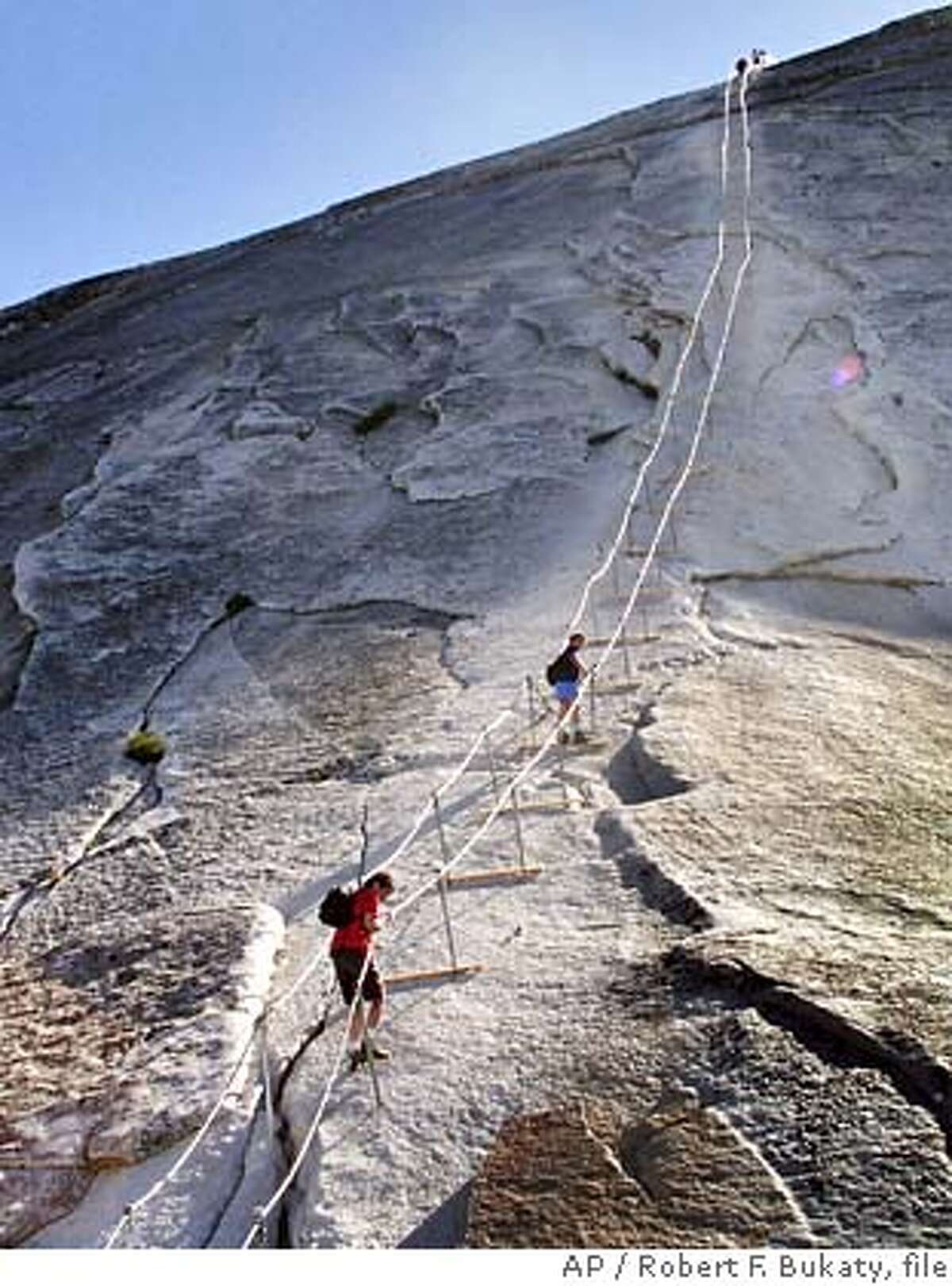** FOR IMMEDIATE RELEASE **Hikers decend the cable route after climbing to summit of Half Dome, June 6, 2004, in Yosemite National Park. In 1875 George Anderson first climbed this route by drilling holes in the granite and attaching ropes to pull himself to the summit. The park has maintained permanent cables here since 1919. (AP Photo/Robert F. Bukaty)