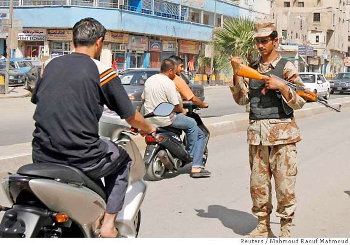 An Iraqi soldier directs traffic at a checkpoint in Baghdad June 17, 2007. Iraqis slowly began returning to the streets of Baghdad when a curfew was lifted on Sunday, four days after the bombing of a revered Shi'ite Muslim mosque to the north sparked fears of reprisal sectarian attacks. REUTERS/Mahmoud Raouf Mahmoud (IRAQ) 0