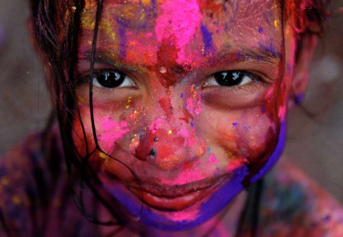 A girl smiles as her face is smeared with colored powder during Holi festival in Kuala Lumpur, Malaysia, Sunday, March 18, 2012. (AP Photo/Lai Seng Sin)