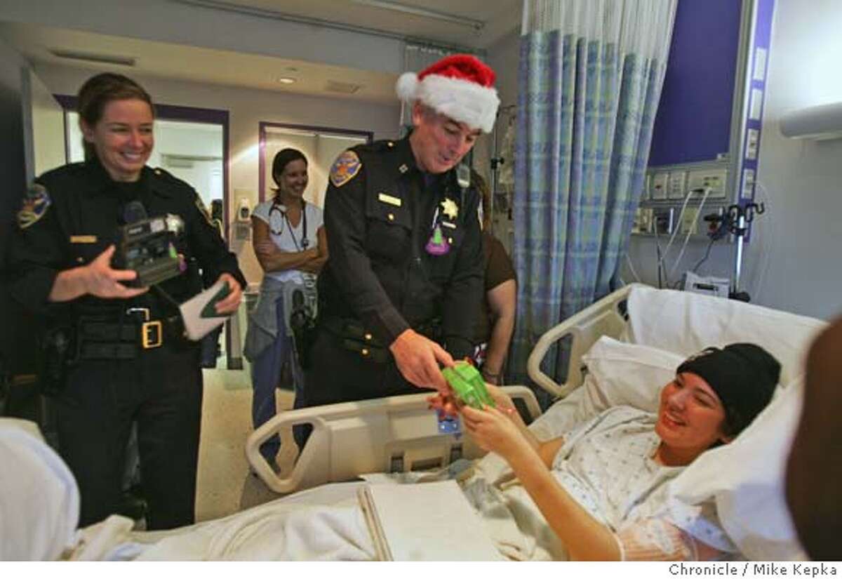 SFPDtoys023seqn}_mk.JPG SFPD officers Laura Knight and Kevin Dillon deliver an iPod shuffle to UCSF children's hospital patient Salina Bajo, 16, who has been in and out of hospitals since July. Several officers from the Northern Station collected 100 toys for almost as many kids at UCSF Children's Hospital. Thursday they delivered the gifts to the hospital. San Francisco on 12/22/05. Mike Kepka / The Chronicle MANDATORY CREDIT FOR PHOTOG AND SF CHRONICLE/ -MAGS OUT