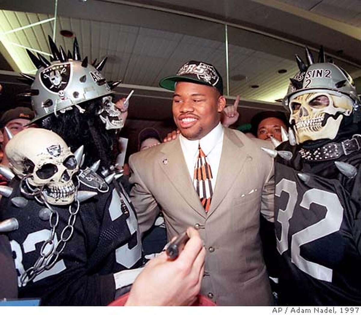 Darrell Russell, defensive tackle from Southern California, center, is surrounded by Oakland Raiders fans after being picked by the Raiders as their first-round pick in the NFL draft in New York, Saturday, April 19, 1997. (AP Photo/Adam Nadel) ALSO RAN 10/28/2003