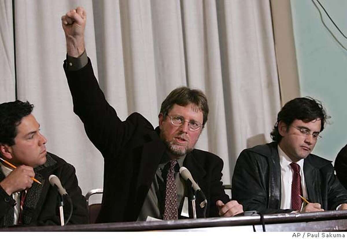 San Francisco Chronicle reporter Kevin Fagan, who witnessed the execution of Stanley Tookie Williams, gestures at a news conference in San Quentin State Prison in San Quentin, Calif., Tuesday, Dec. 13, 2005. Williams, 51, died by injection just after midnight for murdering four people during two 1979 holdups. The gesture referred to how supporters of Williams gestured after the executiion. At left is UPN reporter Tony Lopez and right is Contra Costa Times reporter John Simerman. (AP Photo/Paul Sakuma)