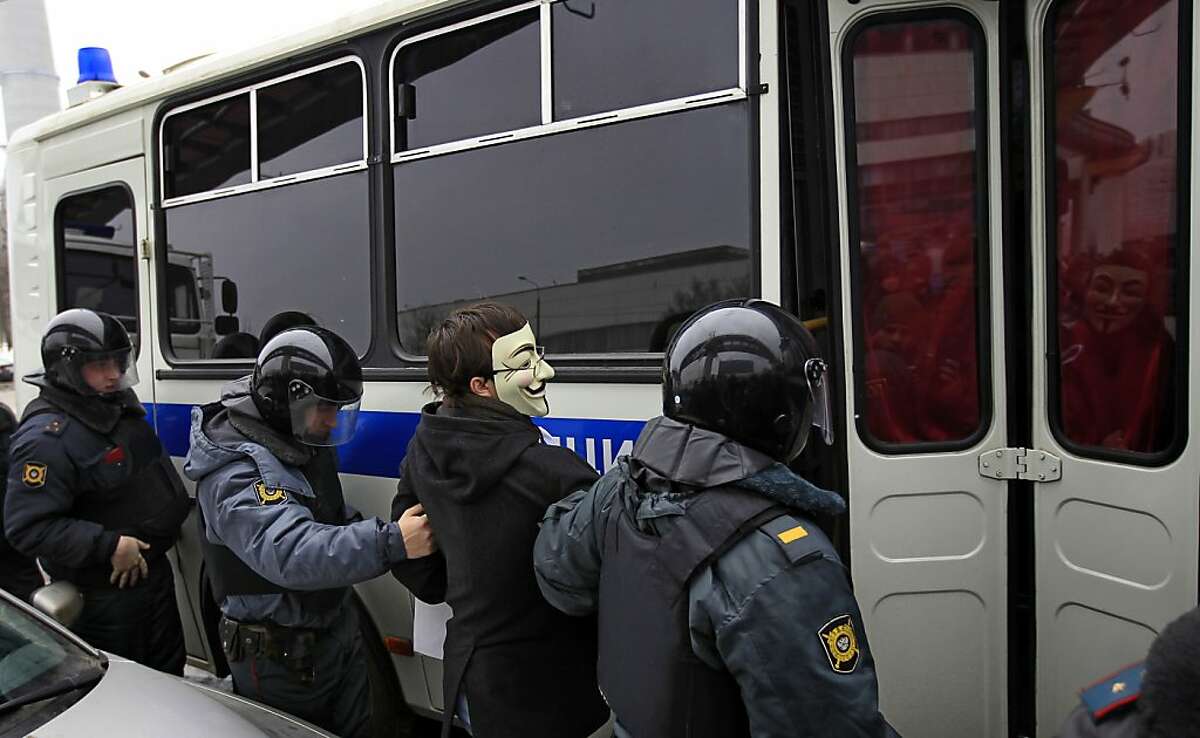 Police officers detain a protester outside the Kremlin-loyal NTV television station in Moscow, Sunday, March, 18, 2012. The NTV documentary program "Anatomy of Protest", which triggered tens of thousands of angry tweets was aired Thursday and portrayed the Russian opposition as paid agents of the United States. (AP Photo/Sergey Ponomarev)