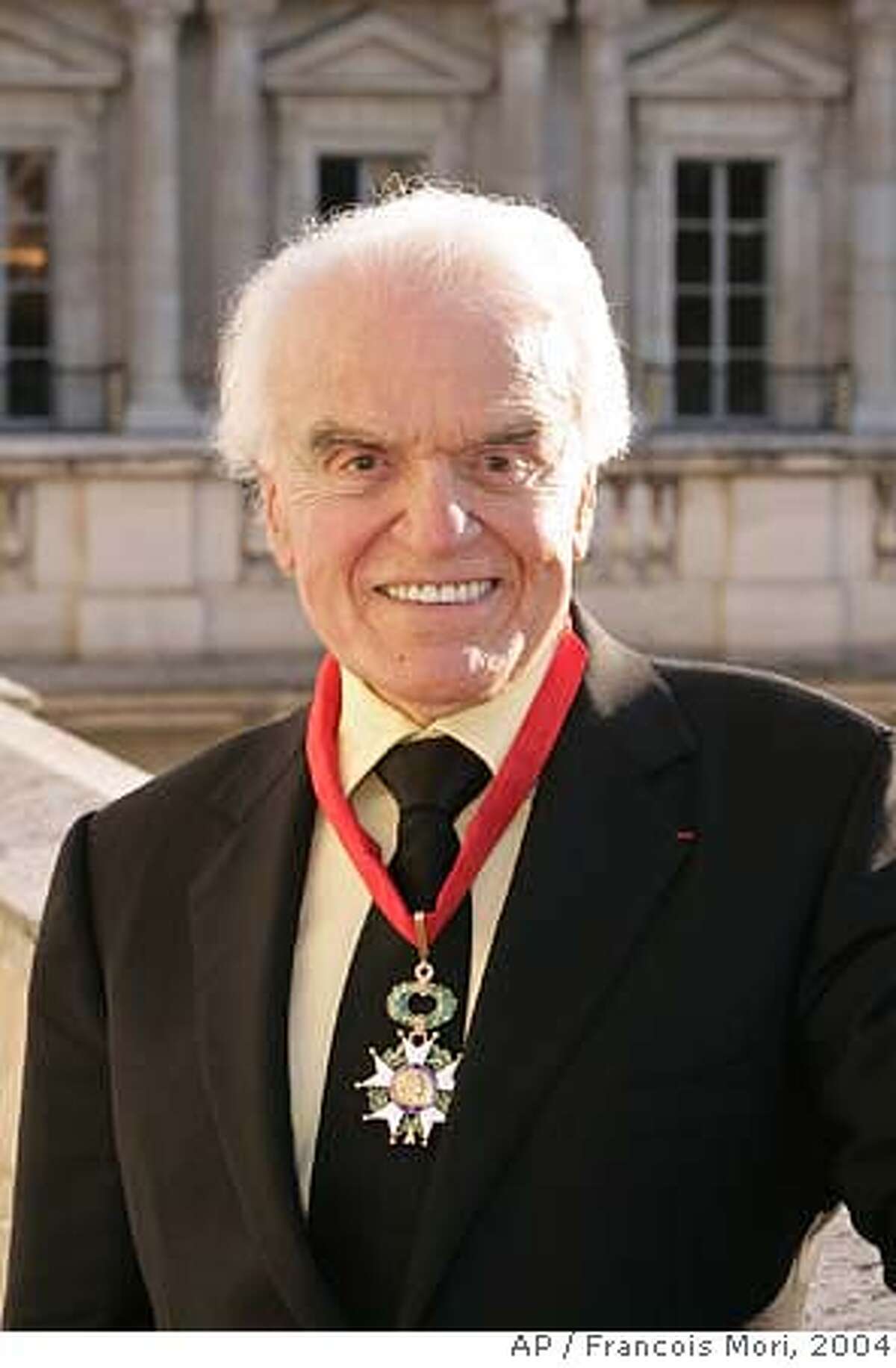 ** FILE ** Former Motion Pictures Association of America (MPAA) president Jack Valenti poses wearing his new insignia outside the French Culture ministry after an awarding ceremony, in this Sept. 6, 2004, file photo in Paris where he was awarded with the distinction of Officer of the Legion of Honor by French Culture Minister Renaud Donnedieu de Vabre. Valenti, the former White House aide and film industry lobbyist who instituted the modern movie ratings system and guided Hollywood from the censorship era to the digital age, died Thursday, April 26, 2007. He was 85. (AP Photo/Francois Mori, file) Ran on: 04-27-2007 Ran on: 04-27-2007 2004 FILE PHOTO