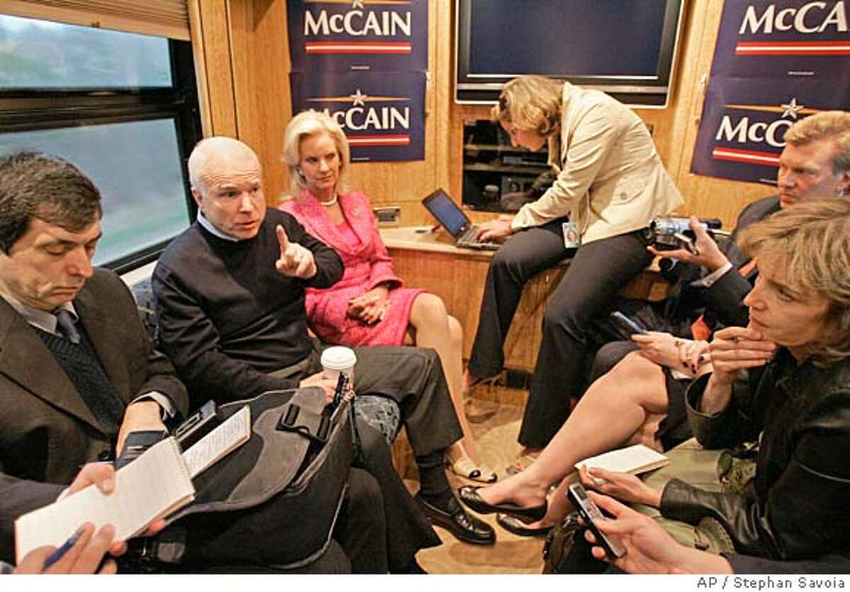 U.S. presidential hopeful Sen.John McCain, R-Ariz., emphasizes a point with reporters while traveling on his campaign bus from Portsmouth, N.H., to Concord, N.H., Wednesday afternoon, April 25, 2007, after he officially announced his candidacy for the presidency. McCain's wife Cindy sits next to him. (AP Photo/Stephan Savoia)