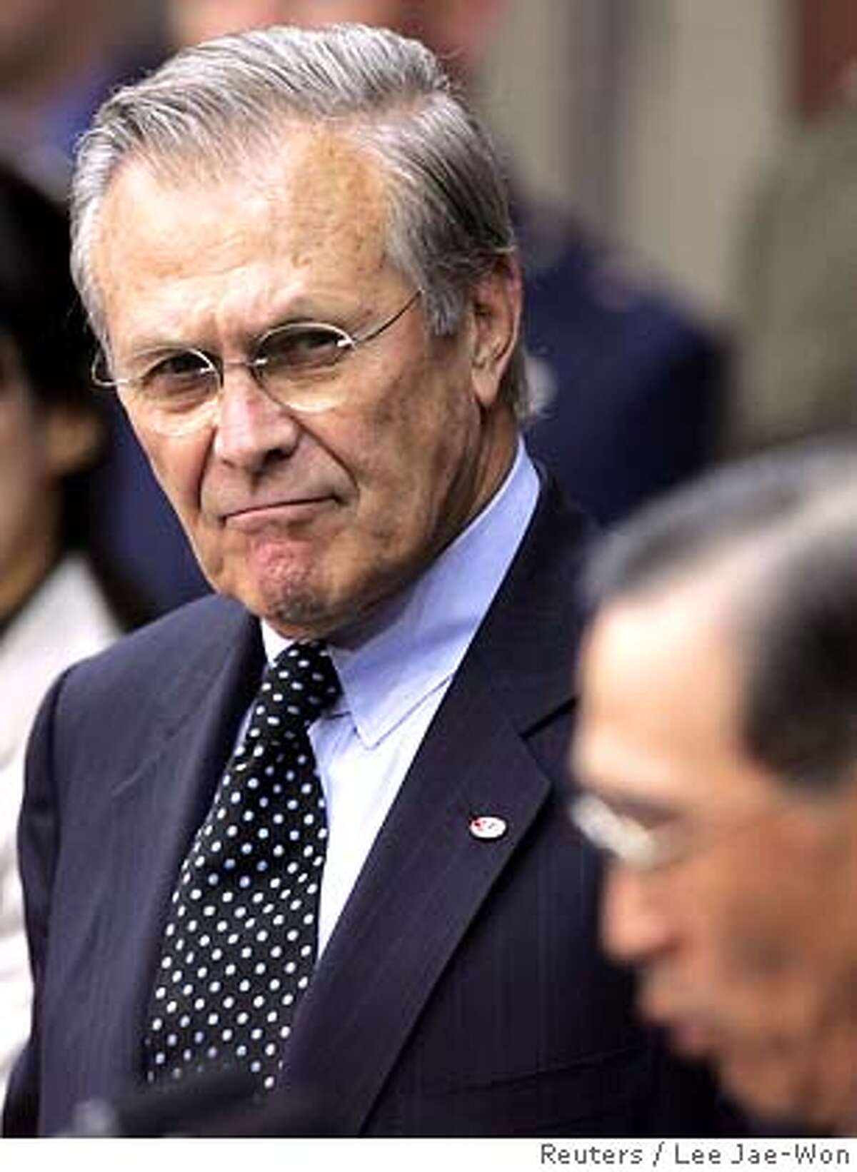 U.S. Defense Secretary Donald Rumsfeld (L) looks at his South Korean counterpart Yoon Kwang-ung during a news conference at Seoul's defence ministry headquarters October 21, 2005. South Korea can expect to take on more responsibility for defending itself but will not be able to take over wartime control from Washington just yet, Rumsfeld made clear on Friday. REUTERS/Lee Jae-Won 0