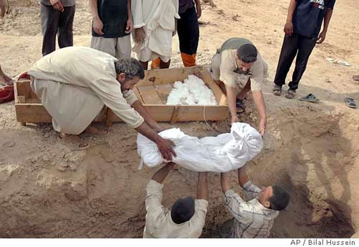 Iraqis lower the body of a US airstrikes victim into the grave in Ramadi, Iraq, Monday Oct. 17 2005, . U.S. warplanes and helicopters bombed two villages near the restive city of Ramadi, killing an estimated 70 militants, the military said Monday, though witnesses said at least 39 of the dead were civilians.(AP Photo/Bilal Hussein)