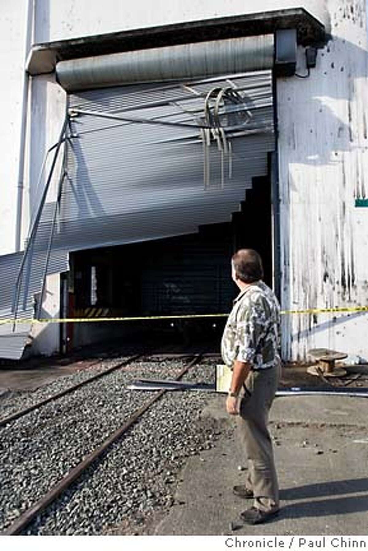 Insurance adjuster Richard Reimche inspects a rollup door which was apparently blown out from the intense heat. ATF agents continue to investigate a warehouse blaze on Oct. 14, 2005 in Vallejo, Calif. More than $100 million in wine, including stock of several well-known Bay Area wineries, was destroyed by a blaze that burned through a former torpedo bunker turned wine warehouse on Mare Island Wednesday. 