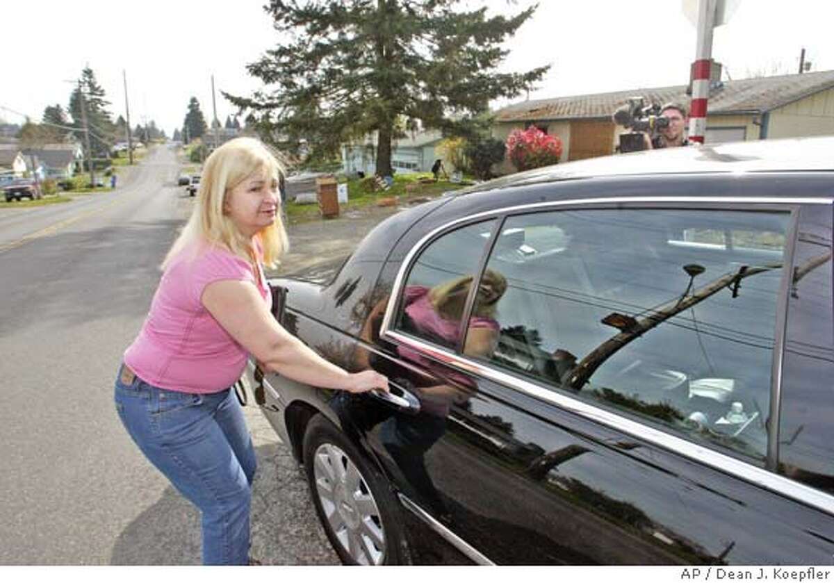 Laurie Raye of Tacoma, whose rental home was stripped of everything including the kitchen sink after a craigslist Internet classified ad invited the public to take anything they wanted for free, slips past local media into a waiting chauffeured car to take her to an interview Thursday, April 5, 2007, in Tacoma, Wash. Raye says the ad, posted last weekend on the craigslist Web site, was fake. After the ad appeared, the property was stripped of the sink, light fixtures and the hot water heater. Even the front door and a vinyl window were pilfered, Raye said. (AP Photo/The News Tribune, Dean J. Koepfler)