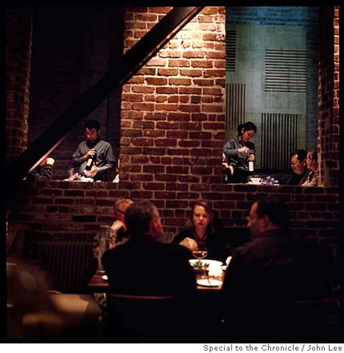 PHOTO FOR THE CHRONICLE MAGAZINE BY JOHN LEE - Servers introduce diners to their respective bottles of wine during a recent Wednesday dinner crowd at the Myth restaurant in San Francisco's Jackson Square district.Ran on: 04-02-2006 A recent Wednesday dinner crowd at Myth restaurant.