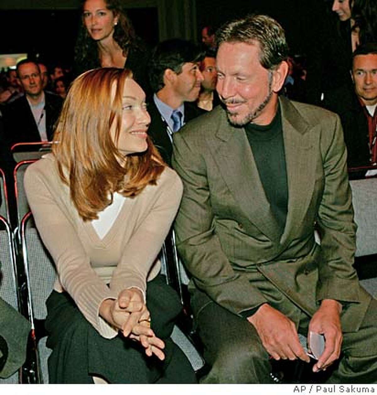 Oracle chief executive Larry Ellison smiles at his wife, Melanie Ellison, before he gave a keynote address at the Oracle Open World Conference in San Francisco, Wednesday, Sept. 21, 2005. (AP Photo/Paul Sakuma)