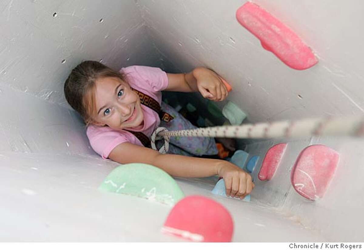 Annaka Olson climbs up the shaft that goes from the basement to the attic. This house in Mountain View has a small backyard, so the parents built slides and secret passages within the house that the children can use for play. There's a slide from the first floor to the basement, rock climbing walls in the basement, a secret passage to the attic from the childrens' bedroom, a shaft from the basement to the attic and other neat features. 5/11/05 in Mountan View,CA. KURT ROGERS/THE CHRONICLE