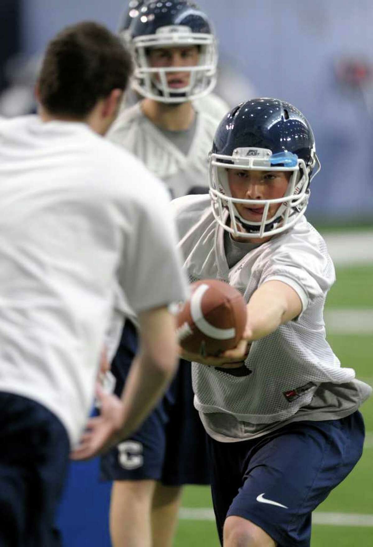 Connecticut quarterback Casey Cochran hands the ball off during the first day of the team's spring NCAA college football practice, Tuesday, March 20, 2012, in Storrs, Conn. (AP Photo/Sean D. Elliot,The Day) MANDATORY CREDIT: SEAN D. ELLIOT/THE DAY