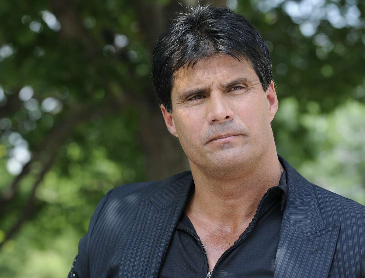 FILE - This June 3, 2010, file photo shows Jose Canseco talking with reporters in Washington. A celebrity boxing promoter has won a default judgment against Jose Canseco for breach of contract after the former major-league slugger instead sent his twin brother for the bout. Damon Feldman, of Broomall, Pa., won his complaint Wednesday, July 20, 2011, after Canseco failed to show for his district court appearance.