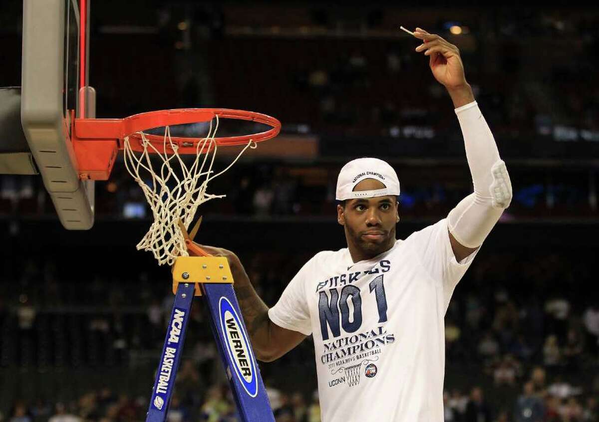 HOUSTON, TX - APRIL 04: Alex Oriakhi #34 of the Connecticut Huskies cuts down the net after defeating the Butler Bulldogs to win the National Championship Game of the 2011 NCAA Division I Men's Basketball Tournament by a score of 53-41 at Reliant Stadium on April 4, 2011 in Houston, Texas. (Photo by Streeter Lecka/Getty Images)