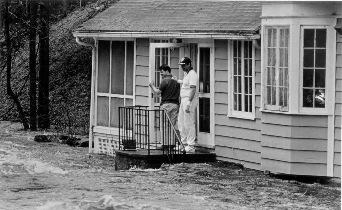 April 4, 1987: John Brodie and his brother-in-law. Doug Lynn, watch the rising waters of the Rippowam River cover five steps of Brodie's back stairs at his home on Maltbie Avenue after a spring storm drenched the region.