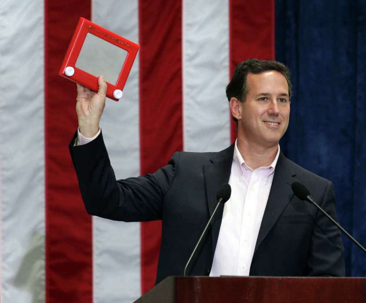GOP presidential hopeful Rick Santorum holds an Etch A Sketch, a low-tech toy that's seen a sudden gain in popularity after a remark by a Mitt Romney strategist, as he speaks Thursday, March 22, 2012, at USAA.