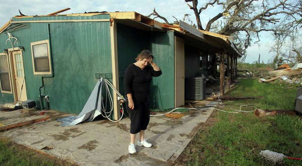 Donna Littleton pauses while looking over the damage that took place at her home Monday night March 20, 2012 on private road 6744 between Lytle and Natalia, Texas. Littleton was at home with her husband James Littleton when she said they heard a loud swirling noise and got into their bath tub for shelter. "We heard the thunder and wind, it was real bad. You could hear the roof coming off, " Littleton said. "Were alive and we're together. That's the main thing," she said.
