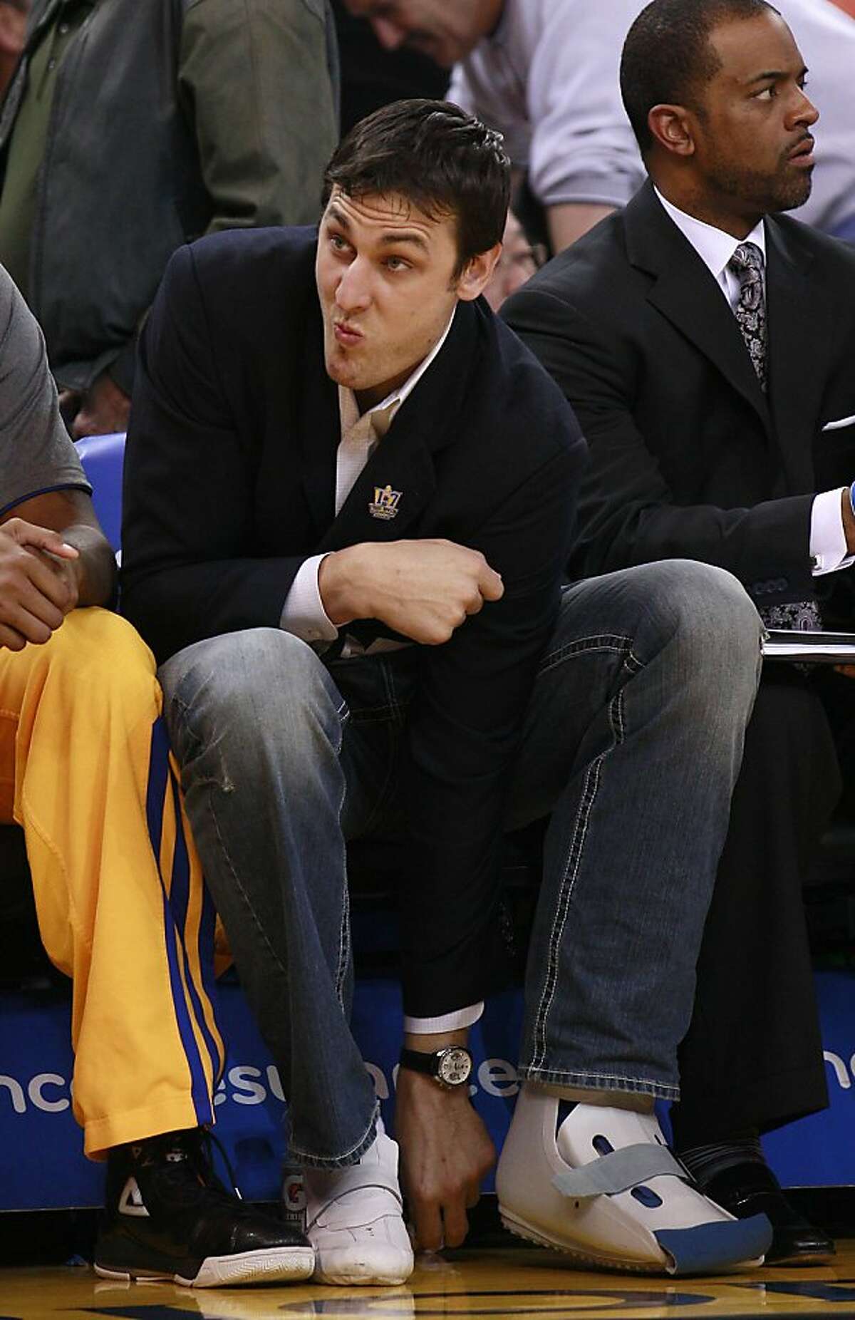 Golden State Warriors center Andrew Bogut, from Australia, sits on the bench during an NBA basketball game against the Minnesota Timberwolves in Oakland, Calif., Monday, March 19, 2012. (AP Photo/Jeff Chiu)